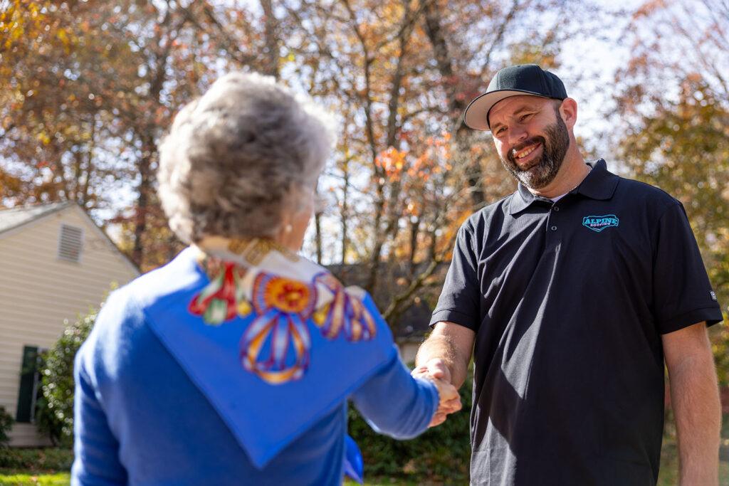 Employee shakes hand with a customer after completing expert roof repair. Near You in Williamsburg, Yorktown, Newport News, Carrollton, and New Kent, VA