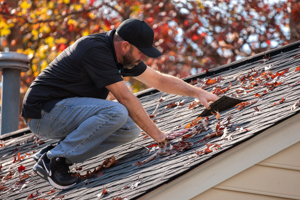 Professional roof installation - Man on roof installing shingles
