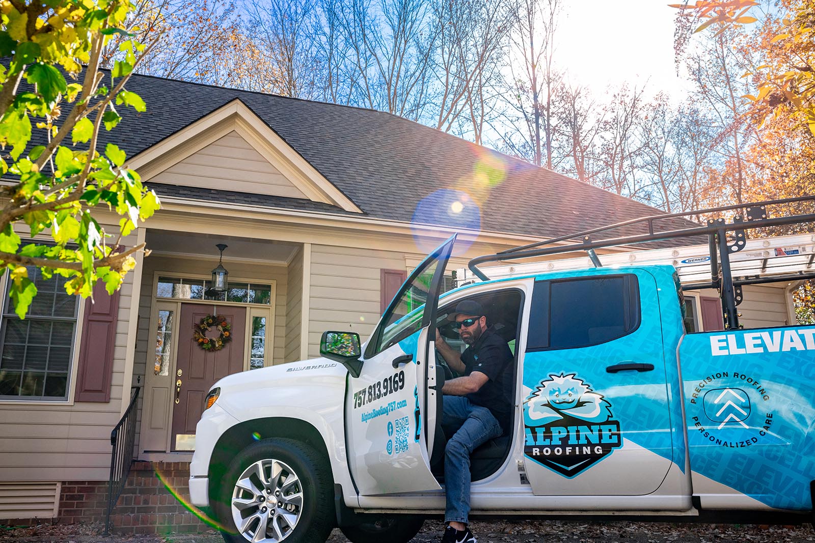 Employee getting out of an Alpine Roofing truck to perform stellar roofing services